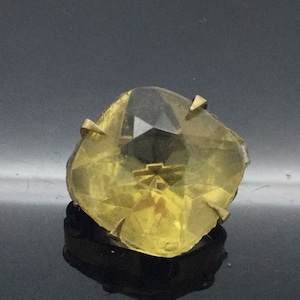 Peut inclure: Une pierre de verre facetée jaune avec des pointes en métal doré. La pierre est sertie dans une forme carrée.
