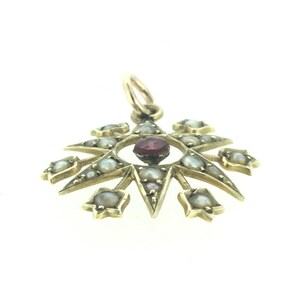 May include: A gold pendant with a red gemstone in the center surrounded by a circle of pearls. The pendant is shaped like a star with eight points.