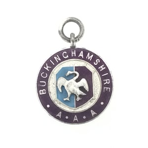 May include: A silver medal with a purple enamel background and a white bird with a blue and purple shield. The medal is inscribed "BUCKINGHAMSHIRE A.A.A."