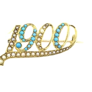 May include: A gold brooch in the shape of the year 1900, set with turquoise and pearl stones.