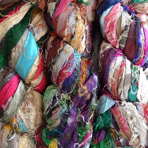 Op de afbeelding: Een bundel kleurrijk zijden lintgaren, met verschillende kleuren en texturen. Het garen is gemaakt van gerecycled zijde en is perfect voor knutselprojecten.