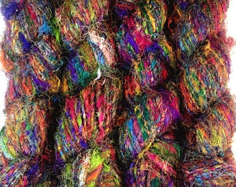 Könnte beinhalten: Fünf Knäuel buntes, mehrfarbiges und strukturiertes Garn. Das Garn ist aus Seide und perfekt zum Stricken oder Häkeln.