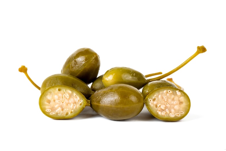 a pile of green fruit sitting on top of a white table