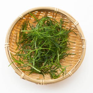 a basket filled with green grass on top of a white table