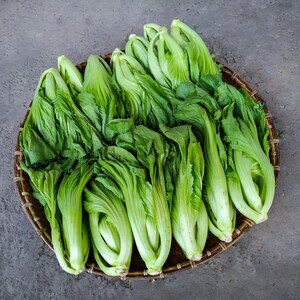 a basket filled with lots of green vegetables