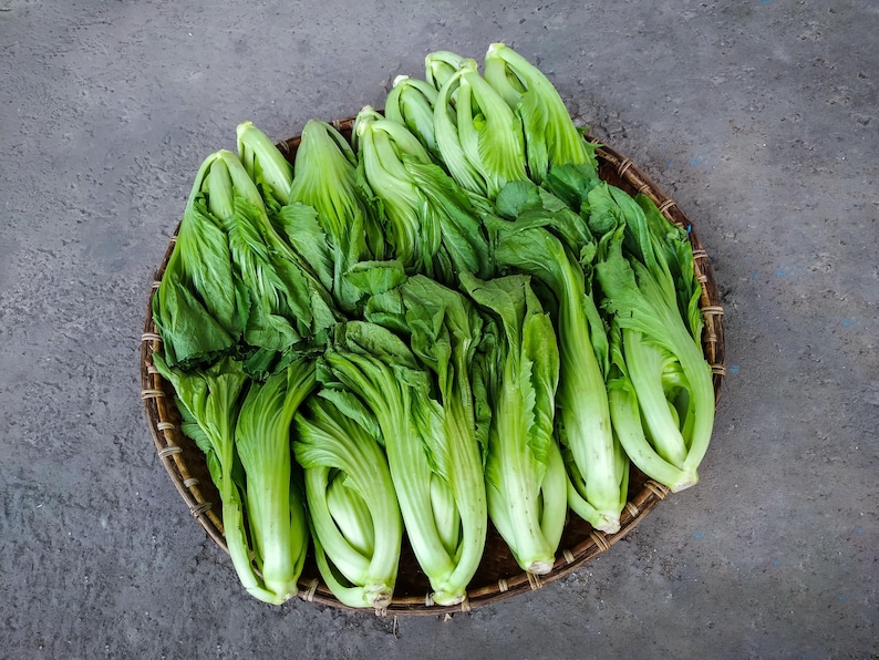 a basket filled with lots of green vegetables