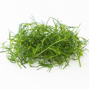 a pile of green grass sitting on top of a white table