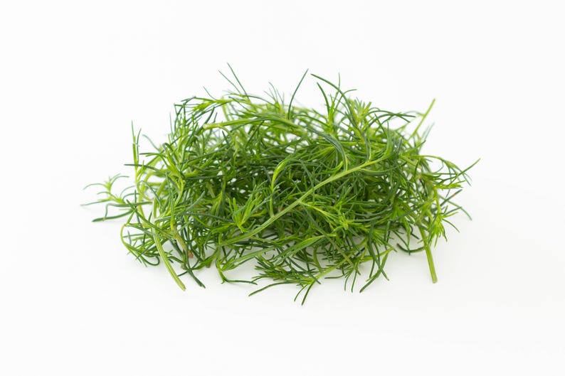 a pile of green grass sitting on top of a white table