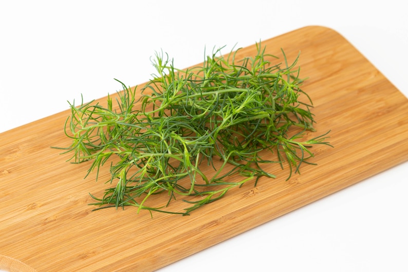 a pile of green grass sitting on top of a wooden cutting board