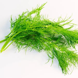 a bunch of green grass sitting on top of a white table