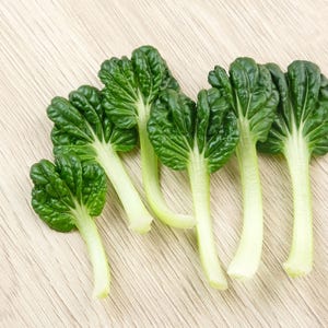 a group of green vegetables sitting on top of a wooden table