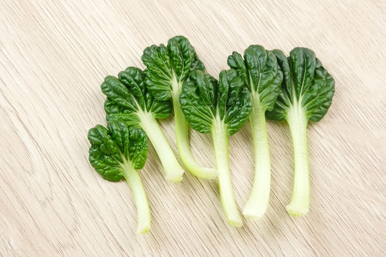 a group of green vegetables sitting on top of a wooden table