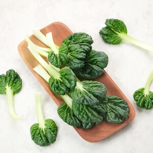 a wooden cutting board topped with green leafy vegetables