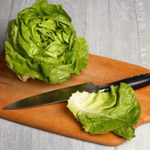 lettuce on a cutting board with a knife