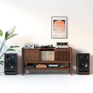 May include: A wooden record player stand with a turntable, amplifier, and speakers. The stand has a shelf for records and a drawer for storage. There is a framed print with the text "bauhaus 1919" above the stand.