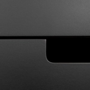 May include: A close-up of a black drawer with a small, rectangular cutout in the front.