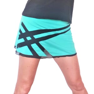 Op de afbeelding: Een turquoise rok met zwarte diagonale strepen. De rok is gemaakt van een lichtgewicht, rekbare stof en heeft een aansluitende pasvorm.