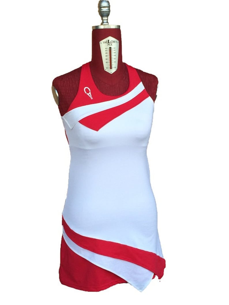 May include: White sleeveless dress with red diagonal stripes and a red and white asymmetrical hem.