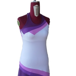 May include: A white sleeveless dress with a purple, pink, and white color block design. The dress has a fitted bodice and a flowing skirt.