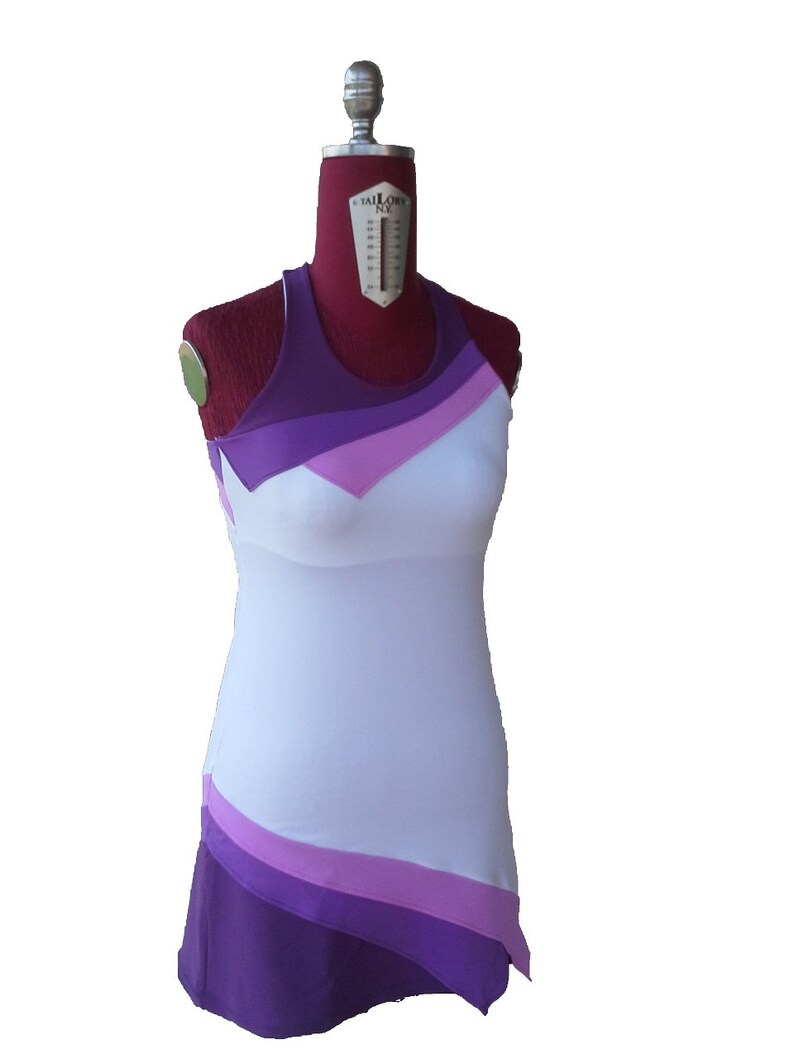 May include: A white sleeveless dress with a purple, pink, and white color block design. The dress has a fitted bodice and a flowing skirt.