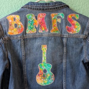 May include: A set of three ceramic mugs with a speckled, matte finish. The mugs are in shades of cream, light gray, and dark gray. Each mug has a simple, minimalist design and a rounded handle.