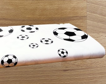 Football fabric white ground with black/white footballs patterned in various sizes 100% cotton can be ordered from 0.5 m