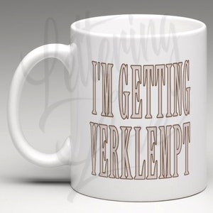 Puede incluir: Taza de cer&aacute;mica blanca con un contorno marr&oacute;n del texto "I'm getting verklempt" impreso en la parte delantera.