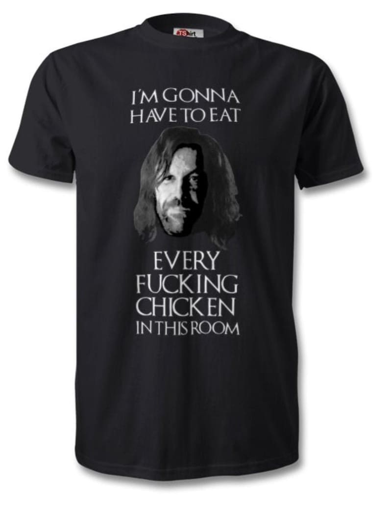 May include: Black t-shirt with a graphic of a man's face and the text "I'M GONNA HAVE TO EAT EVERY FUCKING CHICKEN IN THIS ROOM" in white. The shirt is a crew neck style.