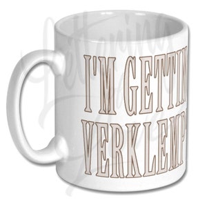 Puede incluir: Taza de caf&eacute; de cer&aacute;mica blanca con un contorno marr&oacute;n del texto "I'm getting verklempt" impreso en la parte delantera.