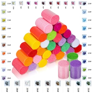 May include: A collection of colorful yarn spools arranged in a pyramid shape. The spools are made of a soft, fluffy material and come in a variety of colors, including pink, green, yellow, orange, red, purple, and blue.