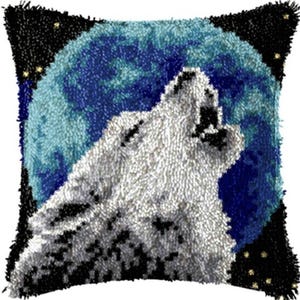May include: Square decorative pillow featuring a white wolf howling at a blue moon. The pillow has a black border with small yellow stars. The wolf's fur is textured, and the moon has a textured appearance.
