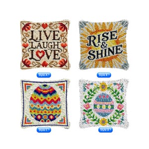 Könnte beinhalten: Vier quadratische Zierkissen mit gestickten Designs. Ein Kissen trägt die Aufschrift "LIVE LAUGH LOVE" mit Herzen und floralen Akzenten. Ein anderes sagt "RISE & SHINE" mit einem Sonnenaufgang. Die anderen beiden zeigen Osterei-Designs.