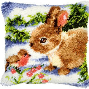 May include: A brown bunny with a pink ear sits in a snowy landscape with a red robin bird. The background is a blue and white winter scene with green trees and red berries.