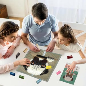 May include: A family is working on a colourful rug hooking project. The project features a pug dog with brown, black, and white fur. The rug hooking kit includes a canvas, yarn, and a tool for hooking the yarn into the canvas.