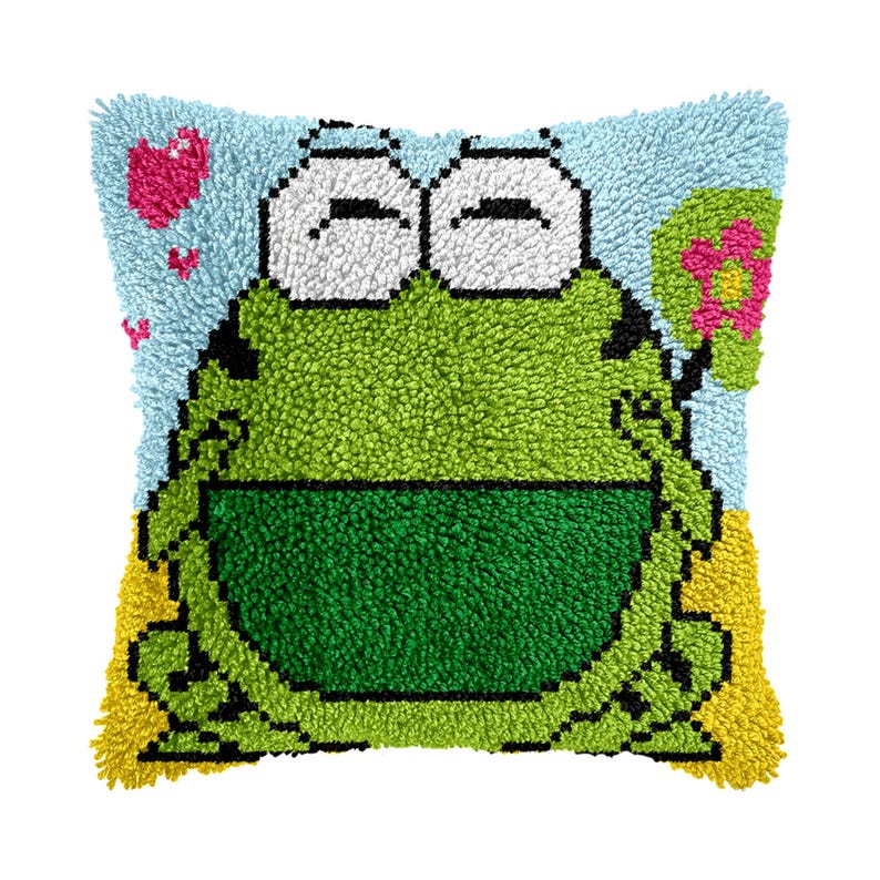 May include: A green frog with big eyes and a smile is holding a pink flower. The frog is on a blue and yellow background with hearts.