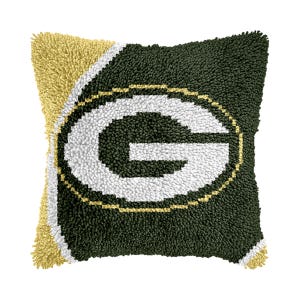 May include: Green and gold plush pillow with a white "G" in the center. The pillow is made of a soft, fuzzy material and is perfect for adding a touch of team spirit to your home decor.