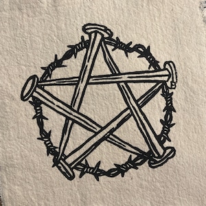 Puede incluir: Cinco palos de madera negros con clavos en los extremos están dispuestos en forma de estrella. La estrella está rodeada por un círculo de alambre de púas negro. El diseño está impreso en una tela beige.