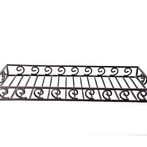 May include: A rectangular, dark metal tray with a decorative, scrolled design. The tray has a grid-like base and scrolled accents along the sides and ends. The tray is elevated by small, curved feet.