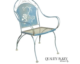 May include: A light blue metal garden chair with a floral design on the backrest. The chair has curved arms and a mesh seat. The text "QUALITY IS KEY decor" is at the bottom right.