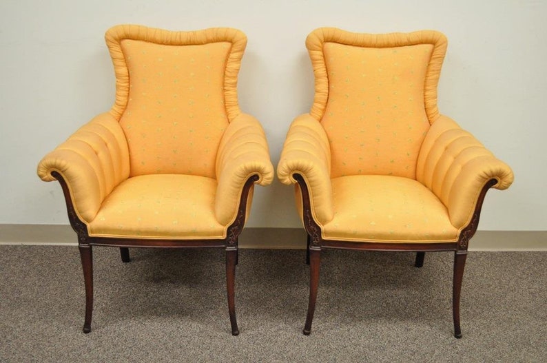 May include: A pair of yellow upholstered armchairs with wooden frames and scrolled arms. The chairs have a tufted back and a patterned fabric.