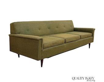 Sofá cama vintage de mediados de siglo, de color marrón verdoso, tapizado con capitoné y patas de nogal.