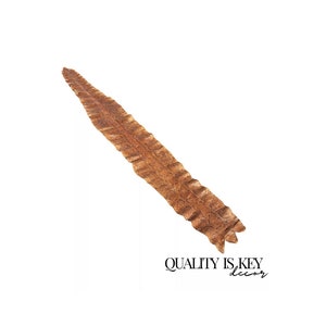 May include: A long, thin, brown snakeskin rug with a textured surface. The rug is about 3 feet long and 4 inches wide.