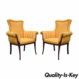 May include: A pair of yellow upholstered armchairs with wooden frames. The chairs have a high back and a curved design.