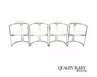 May include: Four white cushioned chairs with chrome frames. The chairs are arranged in a row, facing forward. The chairs have a curved back and a circular seat.