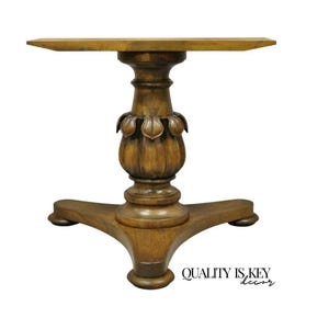 May include: A wooden table base with a carved, leaf-shaped design. The base is a triangular shape with three legs.
