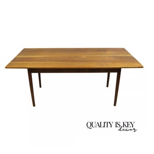 May include: A rectangular wooden table with a light brown finish. The table has four legs and a simple design.