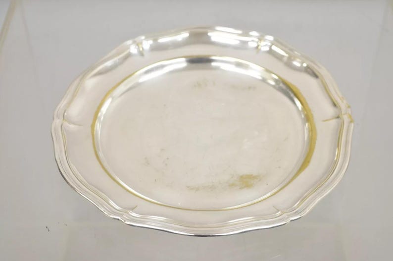 Puede incluir: Un plato de servir de plata con un borde festoneado.