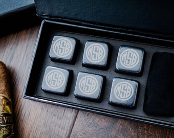 May include: A black gift box with six black square whiskey stones, each engraved with the initials "MSB". The stones are in a black velvet lined box with a black cloth.