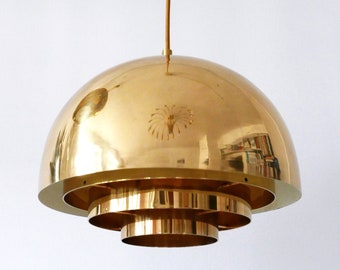 May include: A gold-toned, multi-tiered pendant light fixture with a dome-shaped shade. The light fixture is suspended from a single cord.