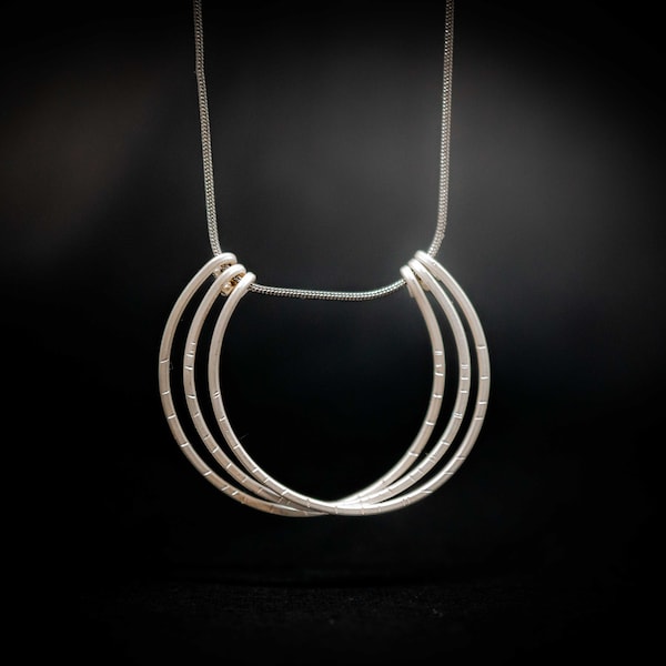 Collar minimalista de plata de ley: círculos superpuestos forjados a mano.